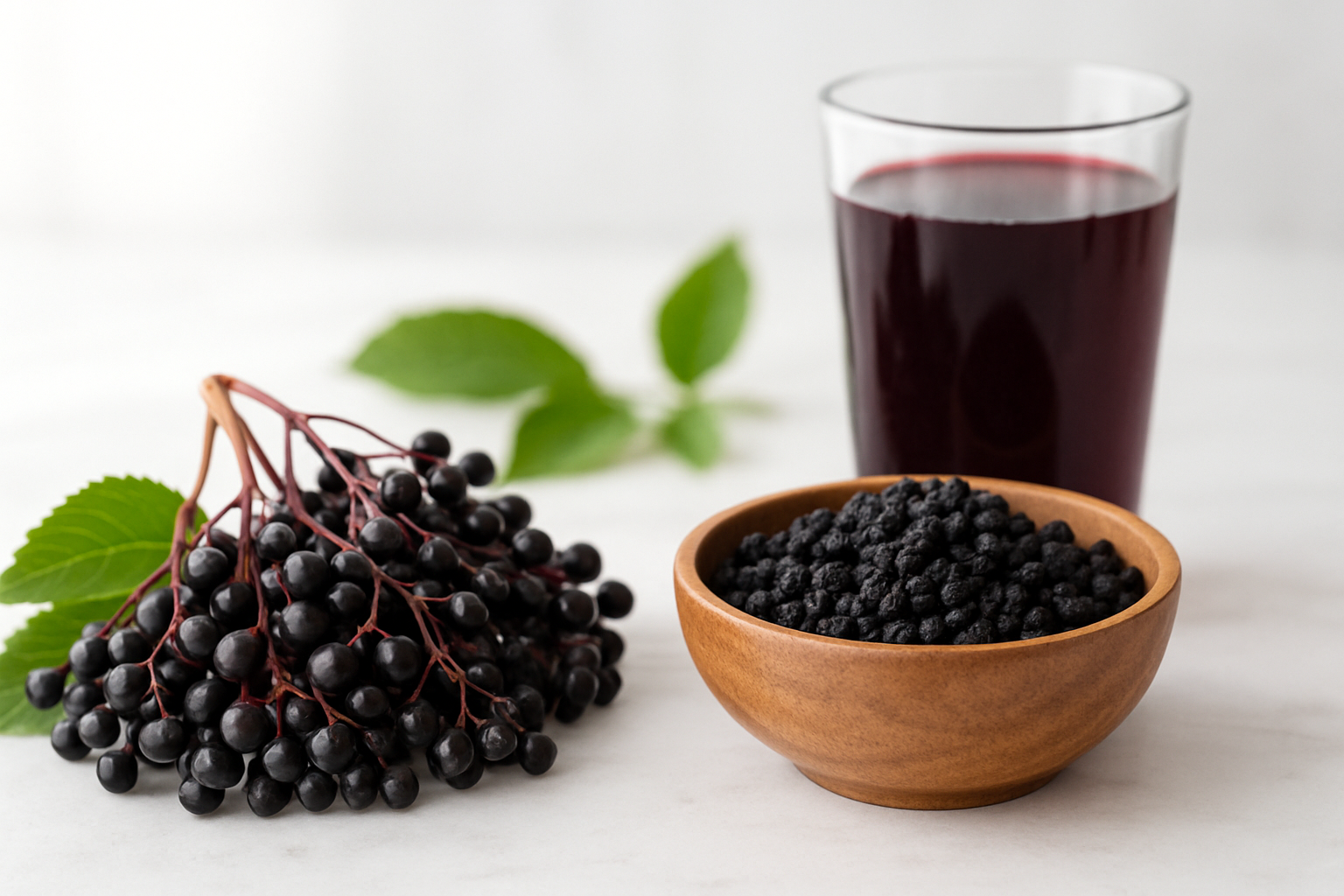 Create a realistic image of fresh dark purple elderberries clustered on their natural stems alongside a wooden bowl filled with dried elderberries, surrounded by subtle visual representations of health and nutrition including a glass of deep purple elderberry juice, fresh green leaves, and soft natural lighting on a clean white marble surface with a bright, clean background that suggests wellness and natural health benefits, absolutely NO text should be in the scene.