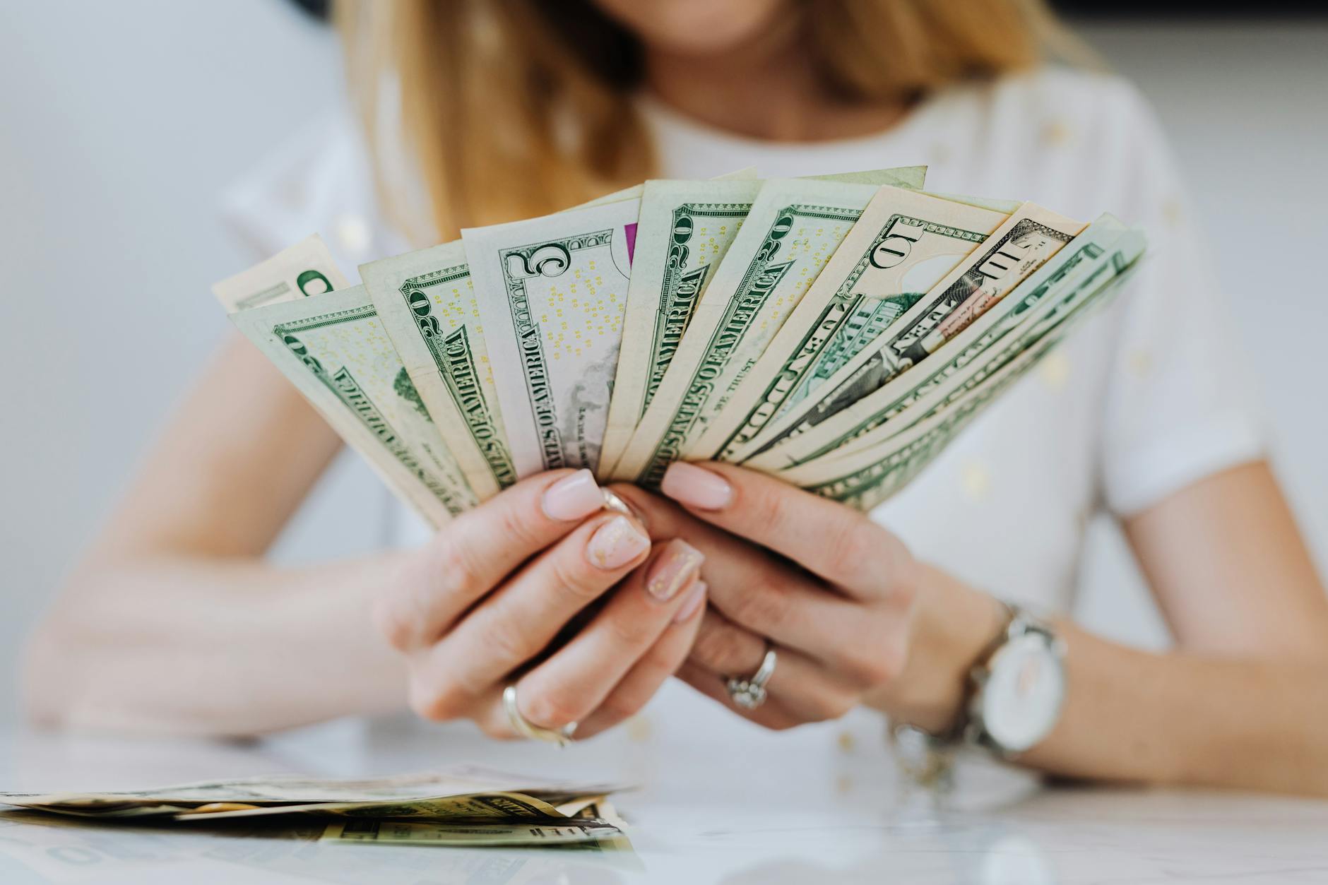 https://www.pexels.com/photo/woman-holding-fan-of-dollar-bills-4968650/